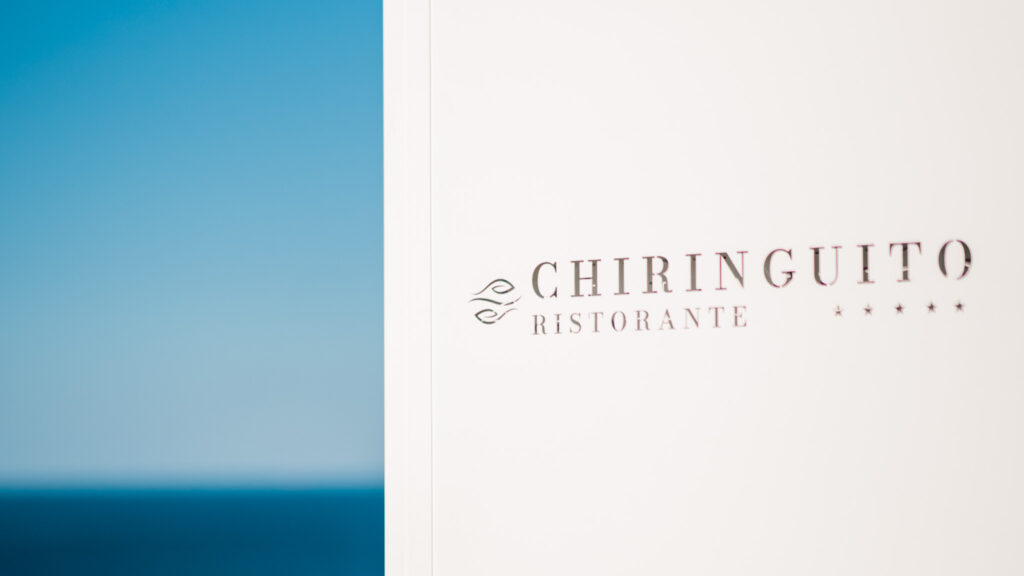insegna ristorante chiringuito e sullo sfondo linea dell'orizzonte sul mare dello Stretto di Messina